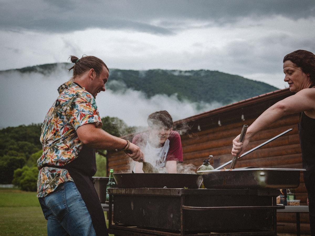 Family gathered around outdoor grill at backyard BBQ reunion